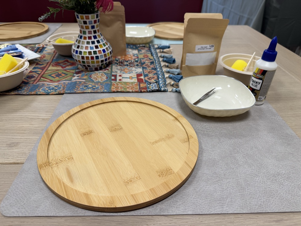 Werkplek met een ronde houten plank, lijm, sponsje en gereedschap
